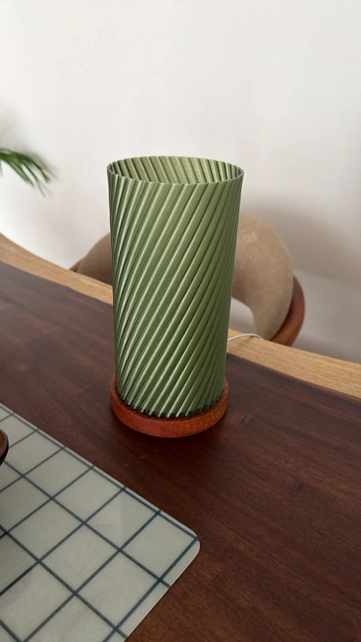Lámpara Tavoa apagada, con pantalla verde de relieves diagonales y base de madera
